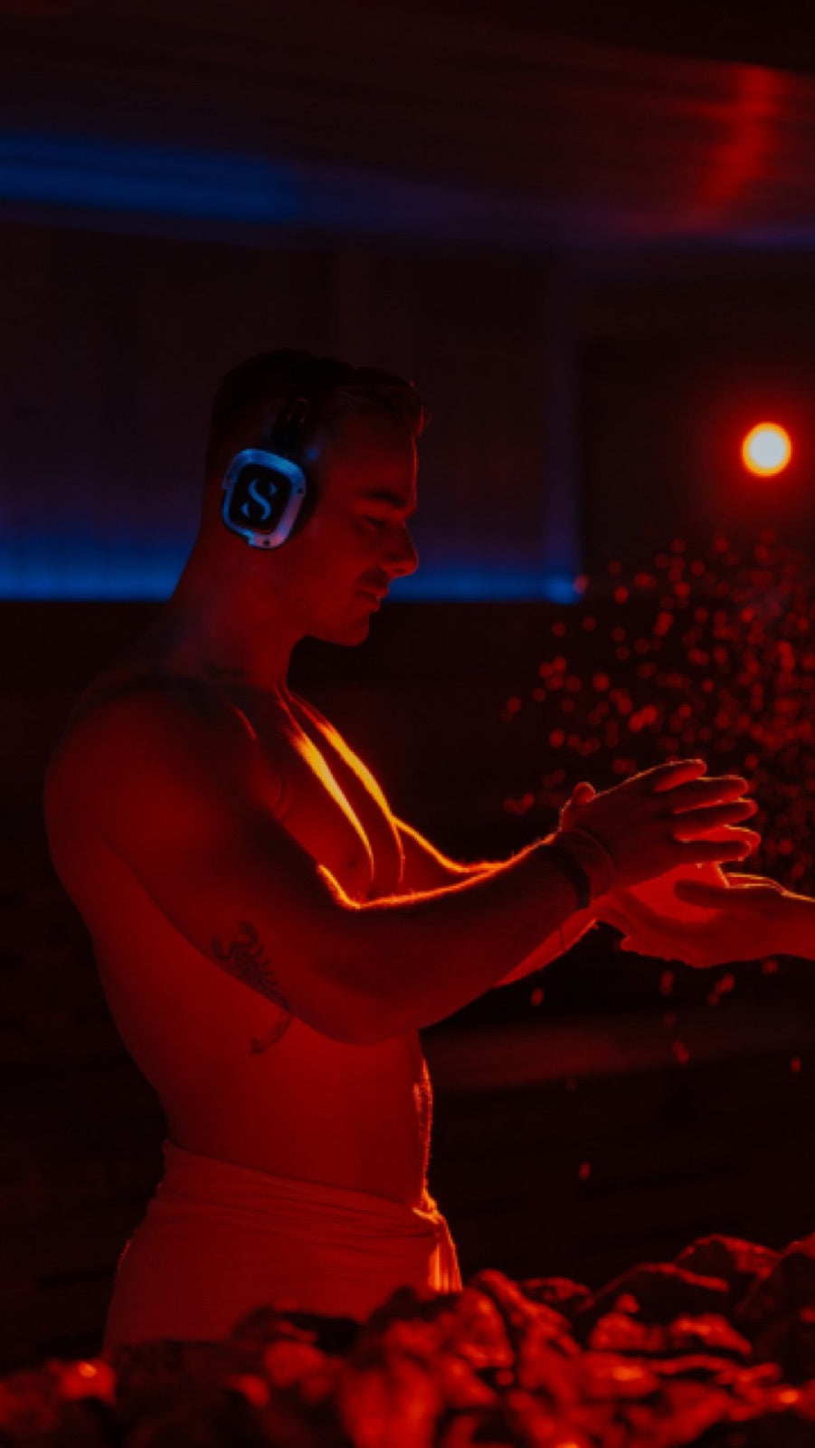 Man in a red-lit sauna after training